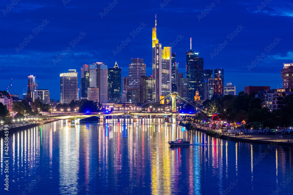 Fototapeta premium FRANKFURT, GERMANY, 25 JULY 2020 Modern cityscape of the business district with reflection on the Main river at night