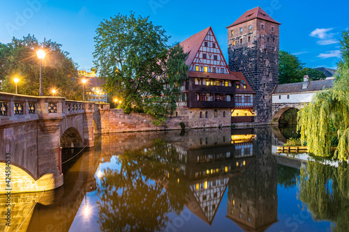 A colourful and picturesque view of the half-timbered old houses on the banks of the Pegnitz river in Nuremberg, Franconia Germany, illuminated at night