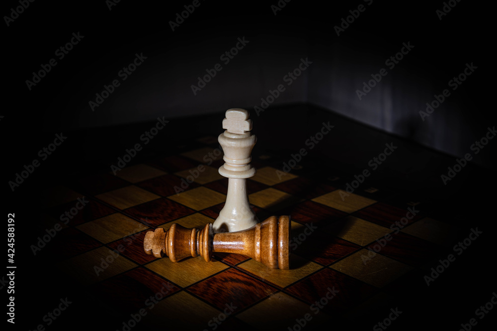 chess pieces in a dark room with an emphasis of light on certain places ...