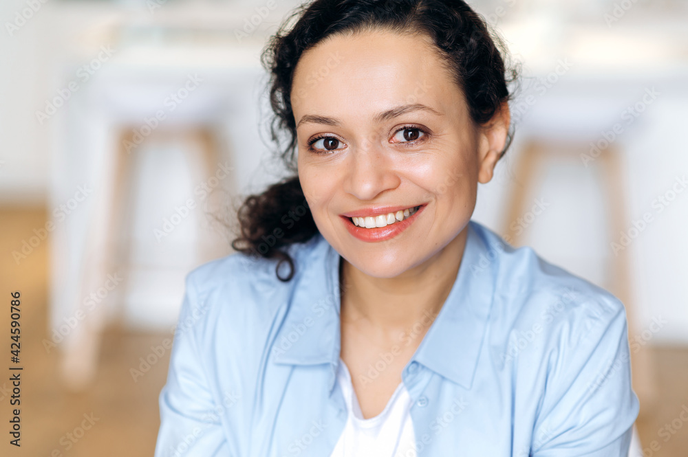 Close-up portrait of an attractive happy confident adult mixed race brunette woman, business lady dressed in stylish clothes, looking at the camera, cute smiling Close-up portrait of an attractive happy confident adult mixed race brunette woman, business lady dressed in stylish clothes, looking at the camera, cute smiling
