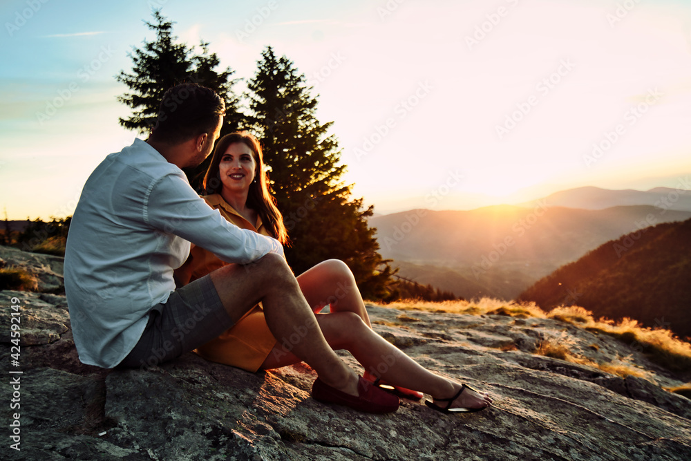 Happy couple hugging on the top of a mountain.