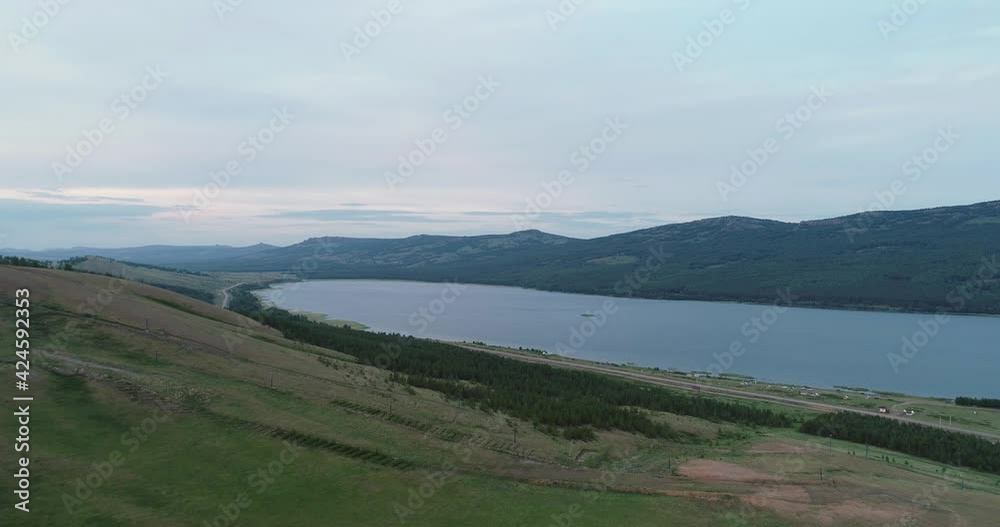 Alpine lake with hills and forest background in Ural Mountains. Aerial drone wide view at summer evening Alpine lake with hills and forest background in Ural Mountains. Aerial drone wide view at summer evening