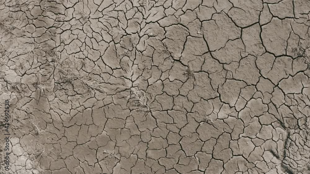 Dynamic shot of cracked soil ground of dried lake or river in mountains. Land destroyed by erosion and global warming - ecological issues concept Dynamic shot of cracked soil ground of dried lake or river in mountains. Land destroyed by erosion and global warming - ecological issues concept