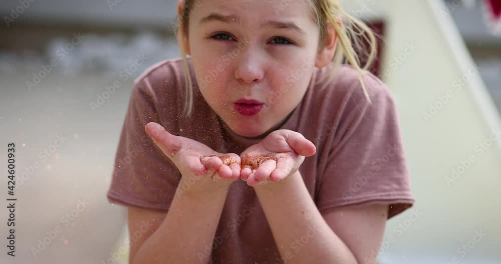 cute kid, boy blowing glitter sparkles from palms