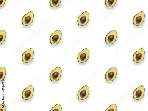 Seamless pattern of fresh ripe green avocado fruit halves isolated on white background. Top view. Flat lay composition