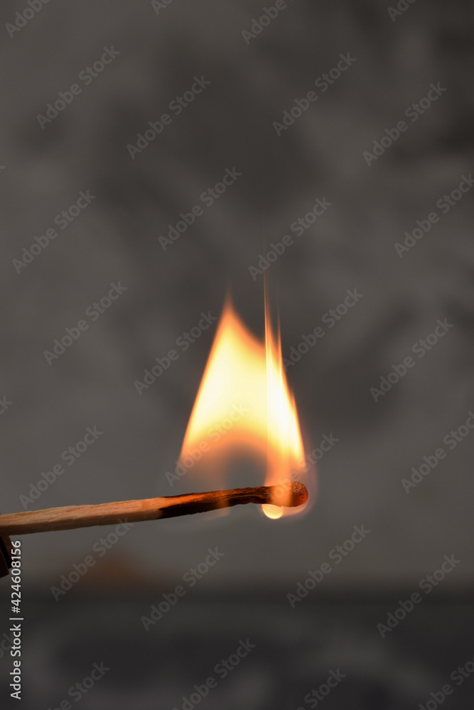 fire.a burning match.gray concrete background.macro fire.a burning match.gray concrete background.macro