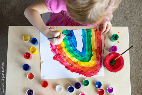 Fototapeta Naklejka Na Ścianę i Meble -  Little child painting with colorful paints sitting at the table at home