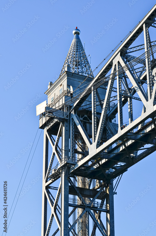 A closeup of the top part of a tower of the Cape Cod Canal Railroad Bridge, a vertical lift bridge in Bourne, Massachusetts near Buzzards Bay. A closeup of the top part of a tower of the Cape Cod Canal Railroad Bridge, a vertical lift bridge in Bourne, Massachusetts near Buzzards Bay.