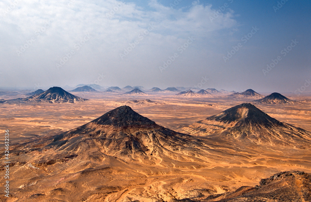 The Black Desert is a region of volcano-shaped and widely spaced mounds, distributed along about 30 km in western Egypt between the White Desert in the south and the Bahariya Oasis in the north. 