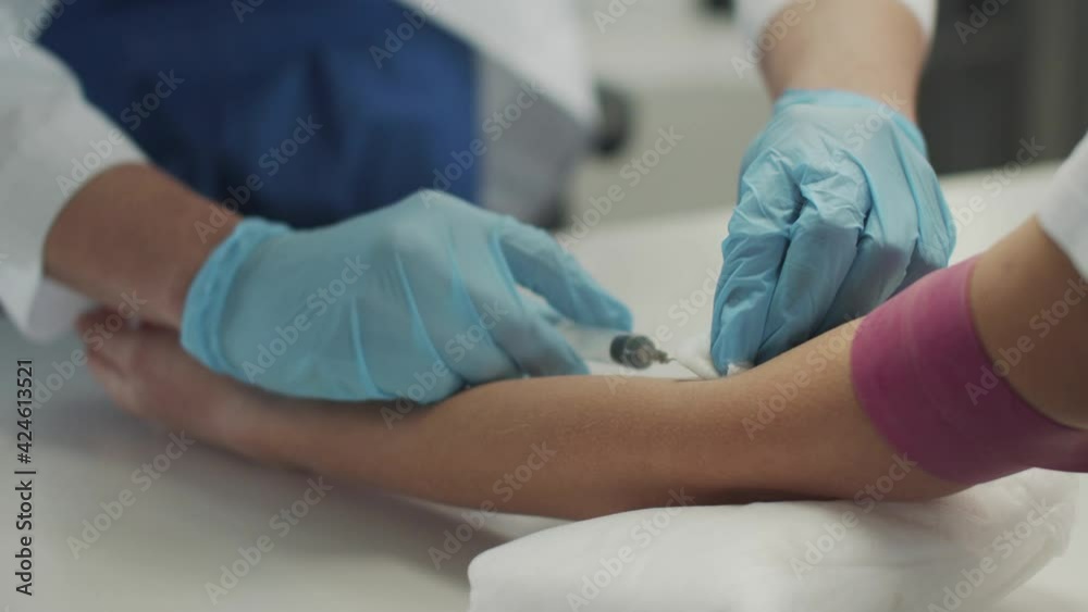 Close-up of an intravenous injection. The doctor jabs a syringe into a vein in the patients arm. Close-up of an intravenous injection. The doctor jabs a syringe into a vein in the patients arm.
