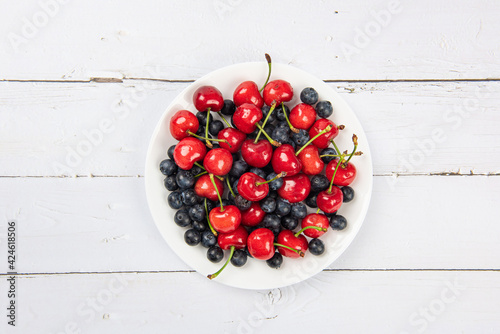 Fresh organic fruit cherry and blueberry on wooden background