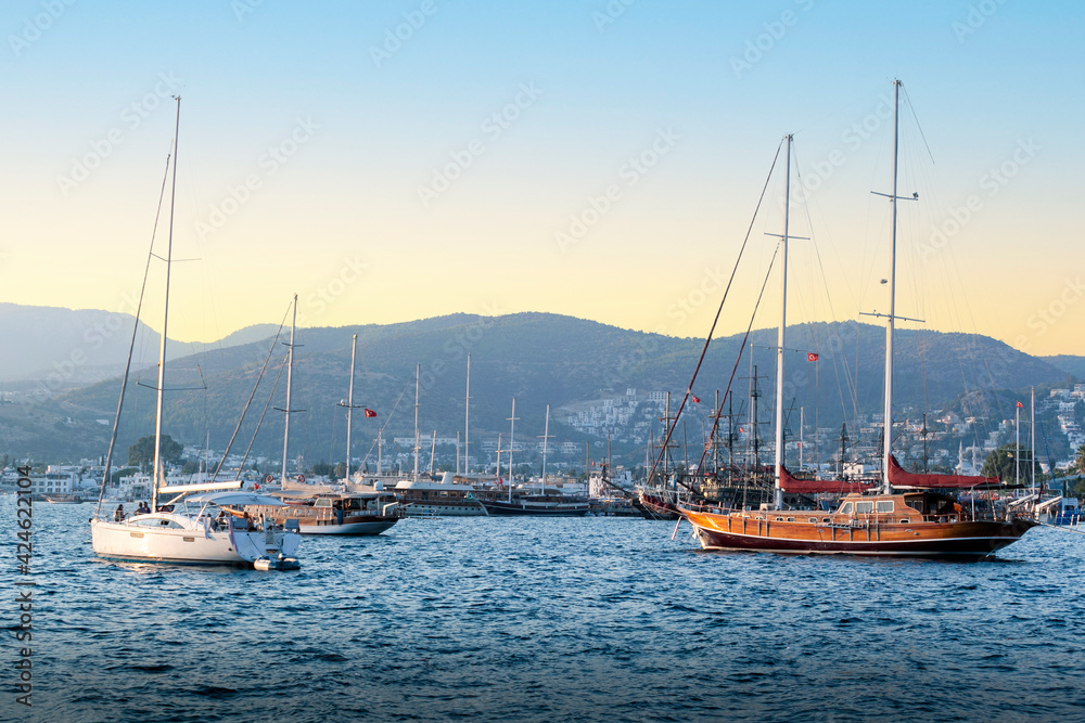 Luxury yachts docked in marina at sunset. Beautiful yachts at coast Aegean sea in Bodrum, Turkey.