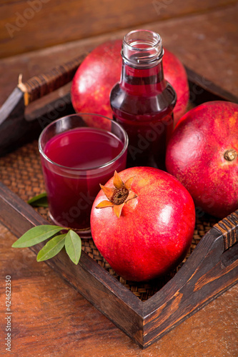 Fototapeta Naklejka Na Ścianę i Meble -  Glass of pomegranate juice on a wooden background.