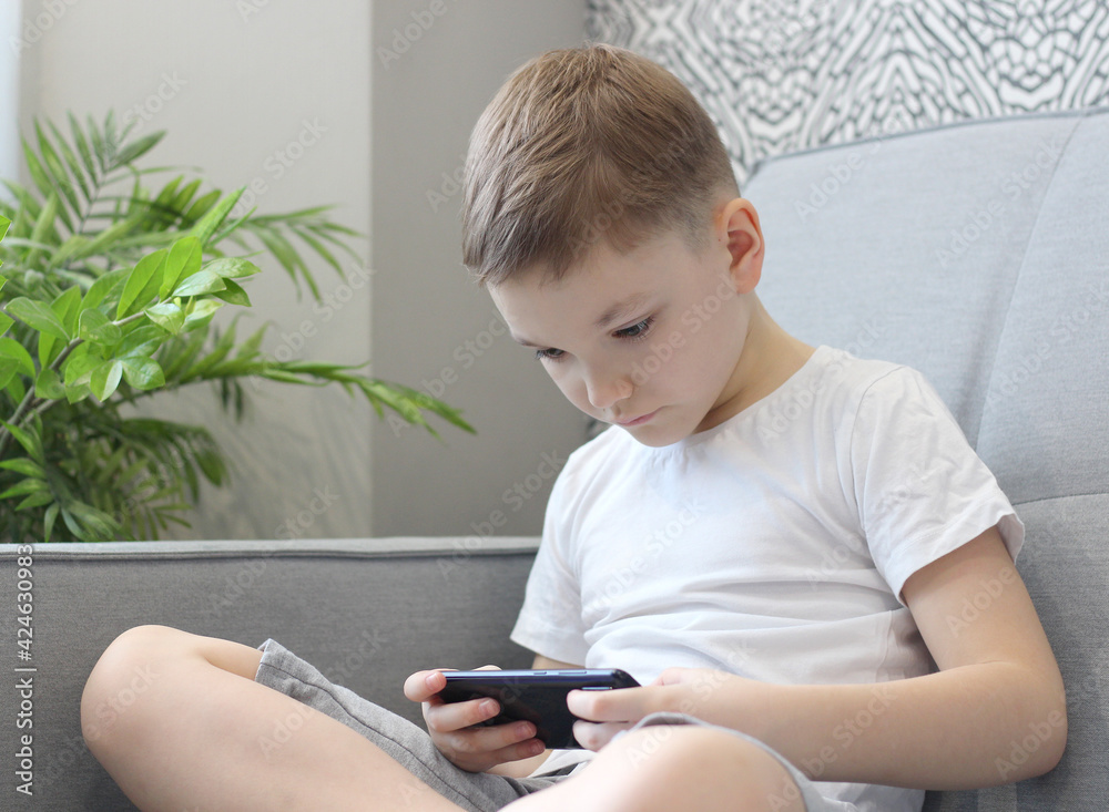 Child Engaged with Smartphone at Home Child Engaged with Smartphone at Home