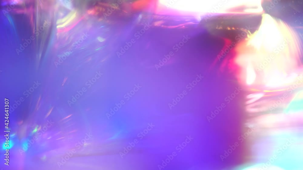 Iridescent sparkling glow. Led neon purple pink gold glowing. Refraction of rays through a prism. Abstract festive moving background for holiday