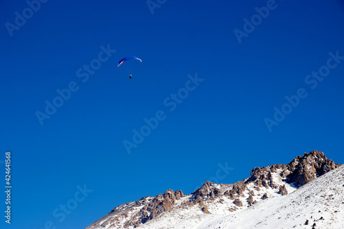 paraglider flying over the mountains on a sunny day