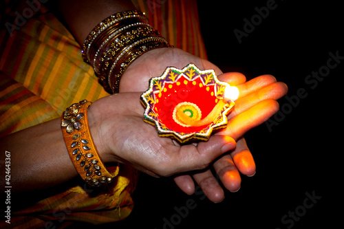 An Hindu lady is seen holding an colorful Oil lamp in her palms for decoration in Diwali festival which is celebrated across Indian sub continent. photo