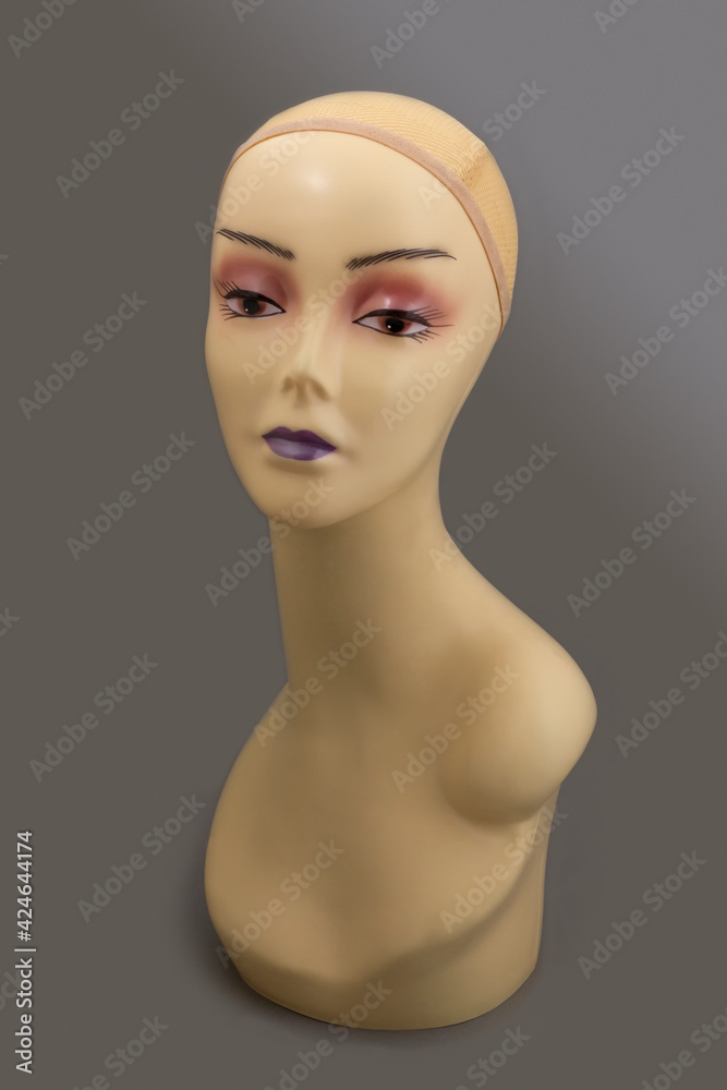 Mannequin full face of a woman's head with makeup without hair on a gray background. Fashion accessories store model for jewelry, wigs, hats, glasses, etc. Mannequin full face of a woman's head with makeup without hair on a gray background. Fashion accessories store model for jewelry, wigs, hats, glasses, etc.