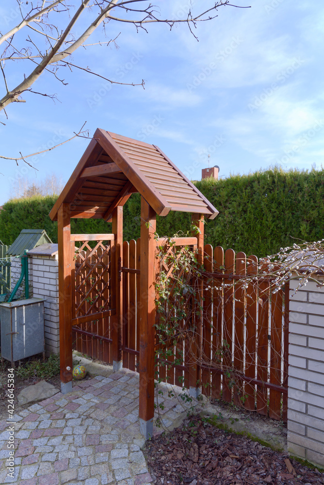 Wooden gate and garden fence and a path from paving stones Wooden gate and garden fence and a path from paving stones