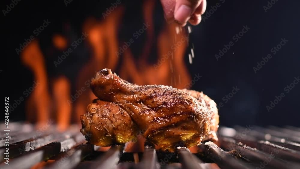 Grilled chicken leg on the flaming grill