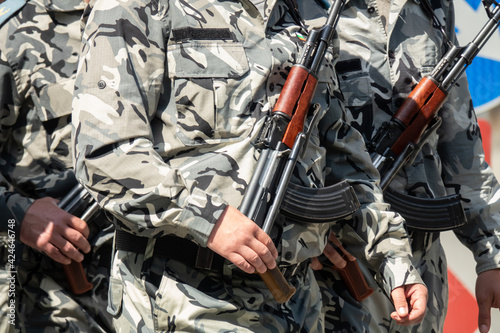 Armed soldiers in camouflage military uniform. Close up soldiers gun in hand