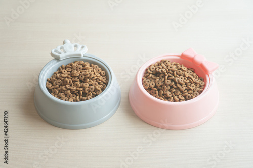 Dry dog food in bowl on wooden table