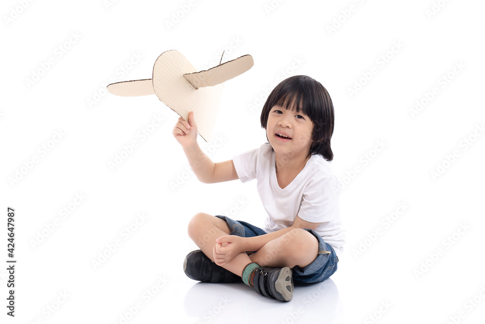 Cute Asian boy playing with cardboard airplane on white background isolated Cute Asian boy playing with cardboard airplane on white background isolated