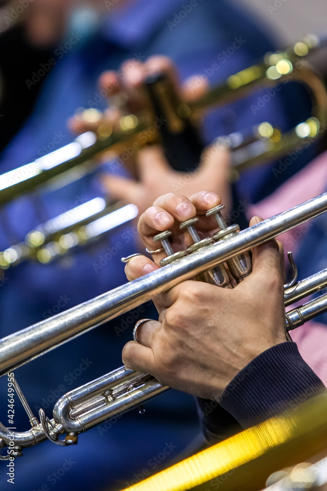 Obraz premium Hands of a musician playing the trumpet in the orchestra close up