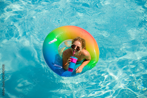 Summertime. Enjoying suntan. Woman in swimsuit on inflatable circle in the swimming pool.