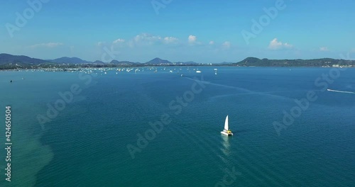 Aerial view. Catamaran goes by sea, camera move closer and fly over vessel, on the sunset, Beautiful view.