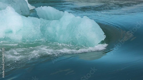 Global warming. Iceland. Melting glaciers and icebergs in the lagoon. A big melting ice block floating towards the ocean in Jokulsarlon glacier lagoon. photo