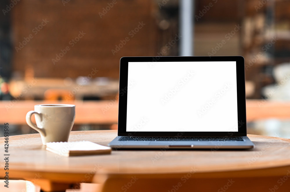 Mockup blank screen laptop with coffee and notebook on the table, Taken from the front. Mockup blank screen laptop with coffee and notebook on the table, Taken from the front.