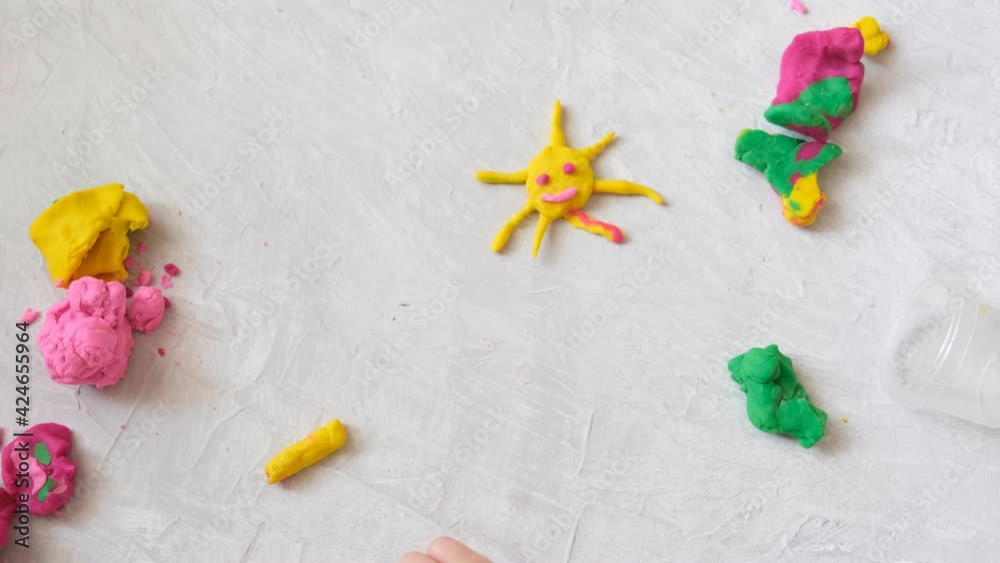 Hands of little girl making flower and sun and other from colorful clay dough, plasticine, Home Education game with clay. Early development concept Hands of little girl making flower and sun and other from colorful clay dough, plasticine, Home Education game with clay. Early development concept