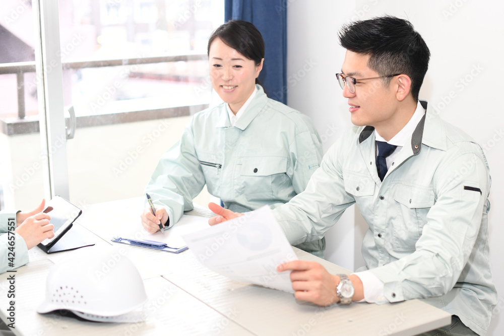 Obraz premium オフィスで会議をする作業服を着た男性と女性 