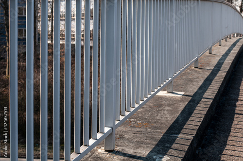 a white painted metal railing at a footbridge