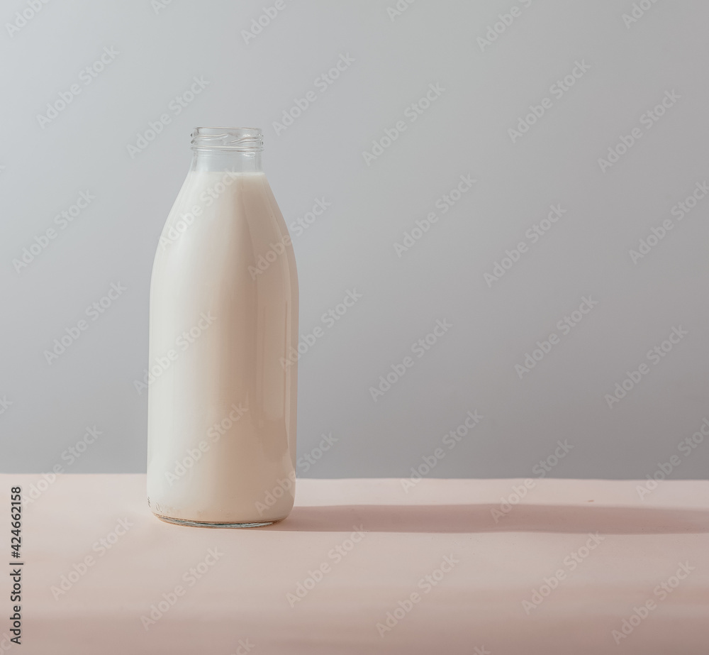 Traditional glass milk bottle on a table on a light background Traditional glass milk bottle on a table on a light background