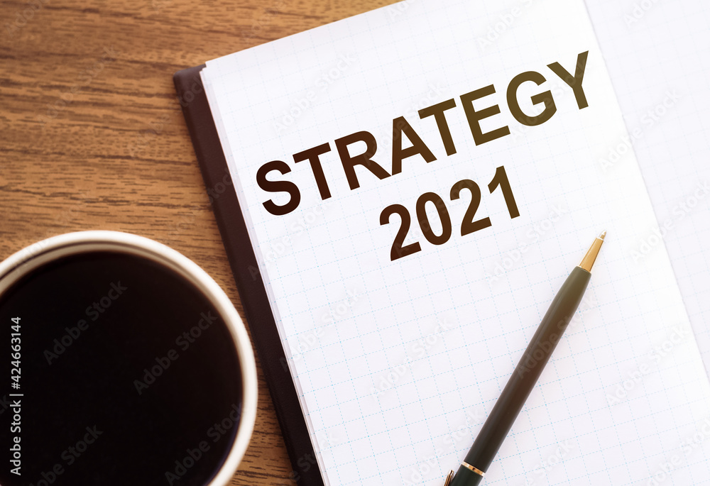 STRATEGY 2021 - text on notepad on wooden desk. STRATEGY 2021 - text on notepad on wooden desk.