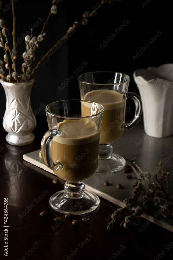 two glasses of cappuccino with a bouquet of willow flowers two glasses of cappuccino with a bouquet of willow flowers