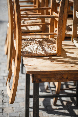 Wooden chairs  inverted  raised on table in street cafe.