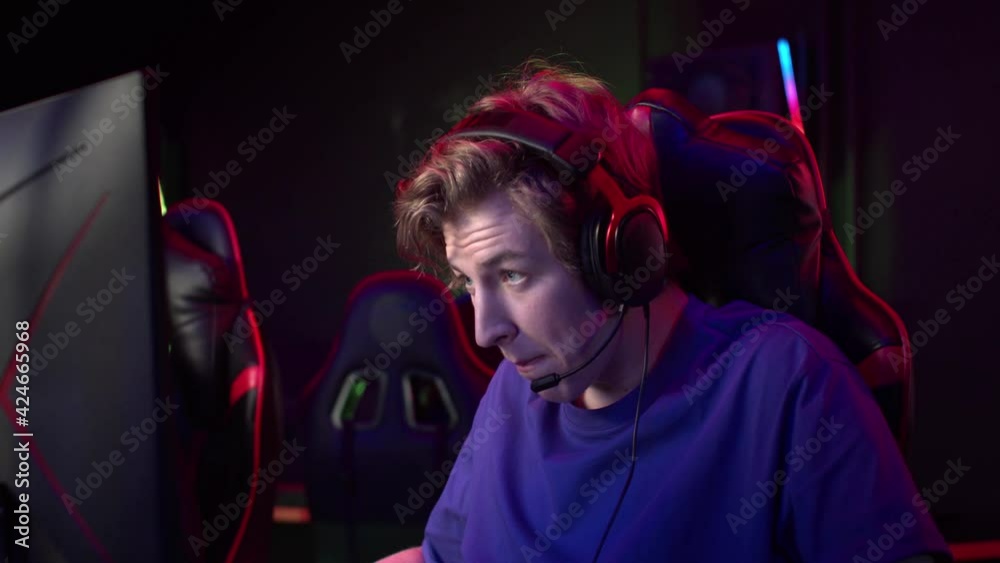 A young streamer leads a live broadcast from the dota championship, speaks a lot into the microphone and gestures A young streamer leads a live broadcast from the dota championship, speaks a lot into the microphone and gestures