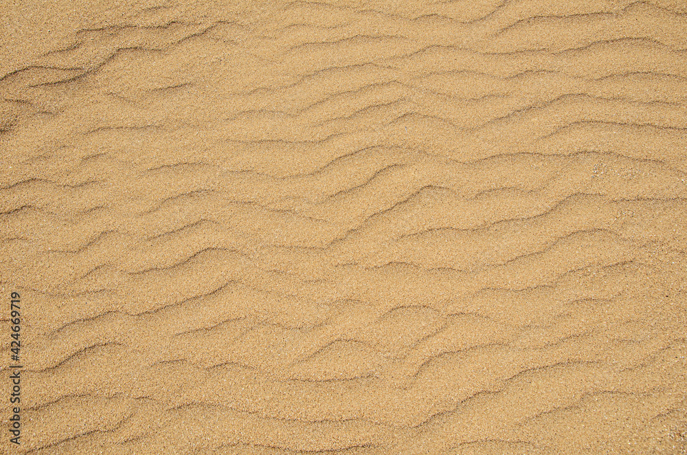 Texture of coarse yellow sand on the beach. Sand dune background. View from above. Background image for design, pattern Texture of coarse yellow sand on the beach. Sand dune background. View from above. Background image for design, pattern