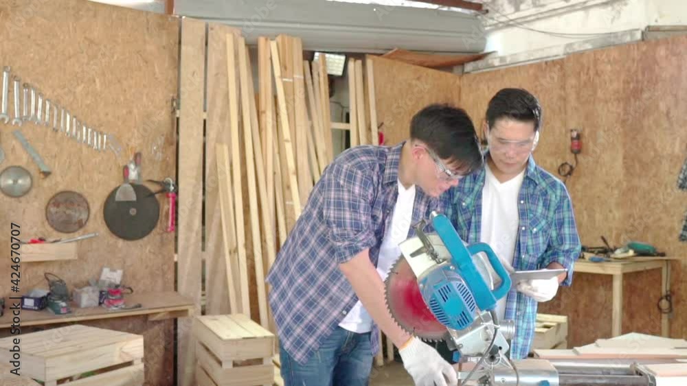 Concentrated man cutting wooden board. Carpenter cutting wood on circular saw. Concentrated man cutting wooden board. Carpenter cutting wood on circular saw.