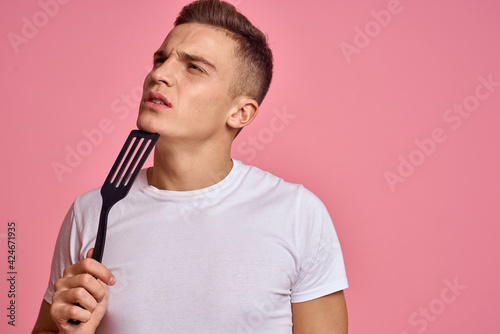 Man in white t-shirt at home in the morning kitchen lifestyle pink background