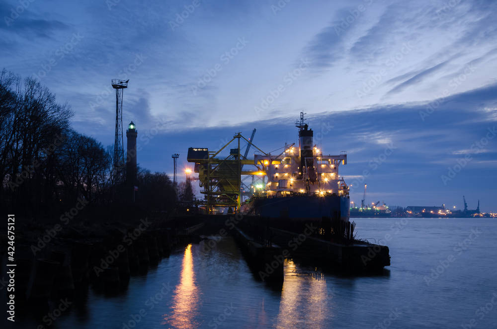 MARITIME TRANSPORT - A merchant vessel at a transshipment quay in a seaport 