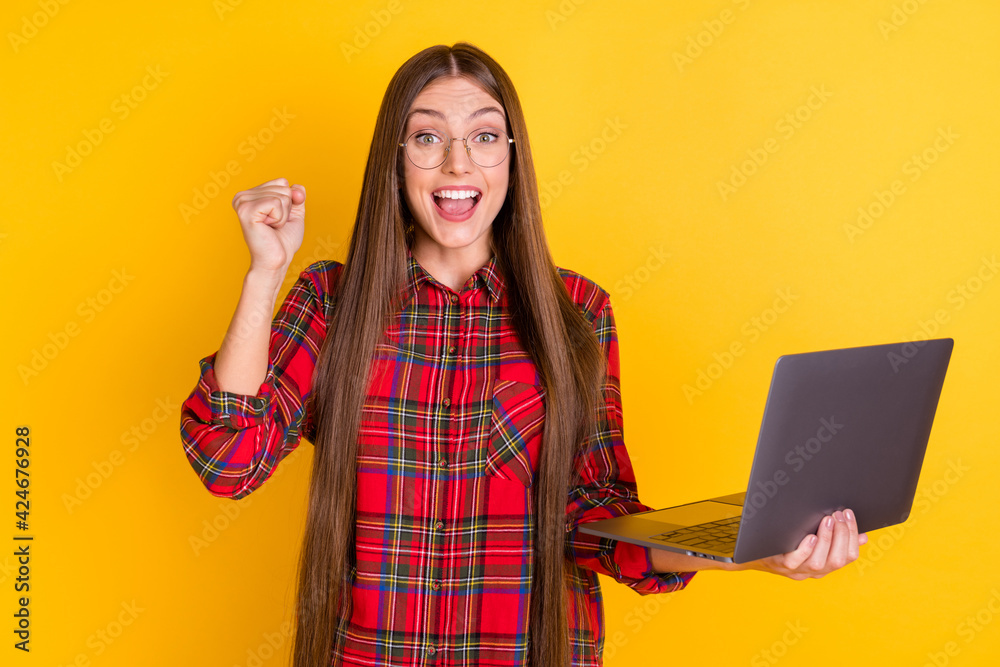 Portrait of nice hooray brunette long hairdo lady hold laptop wear spectacles red shirt isolated on vivid yellow color background Portrait of nice hooray brunette long hairdo lady hold laptop wear spectacles red shirt isolated on vivid yellow color background