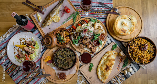 A lot of food on the wooden table. Georgian cuisine. Top view. Flat lay . Khinkali and Georgian dishes