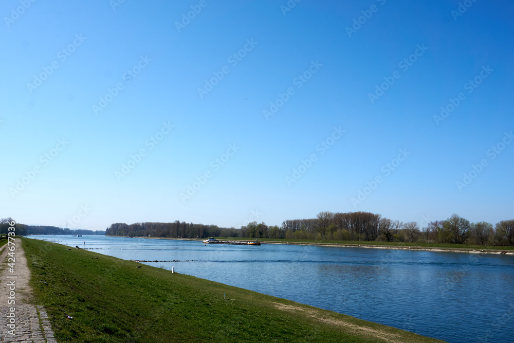 beautiful rhine river with blue water in sunshine in the middle of green landscape