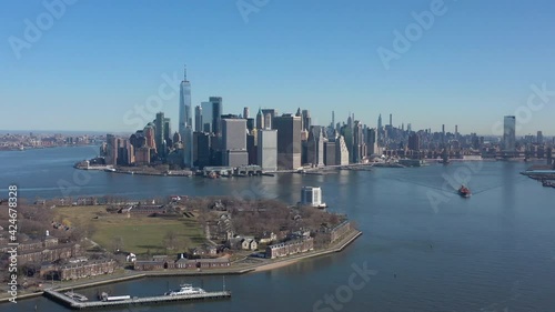 Wallpaper Mural An aerial view of New York harbor on a sunny day with blue skies. The camera truck right, boom up and dolly in high enough to see Governors Island ventilation tower and Manhattan in the background. Torontodigital.ca