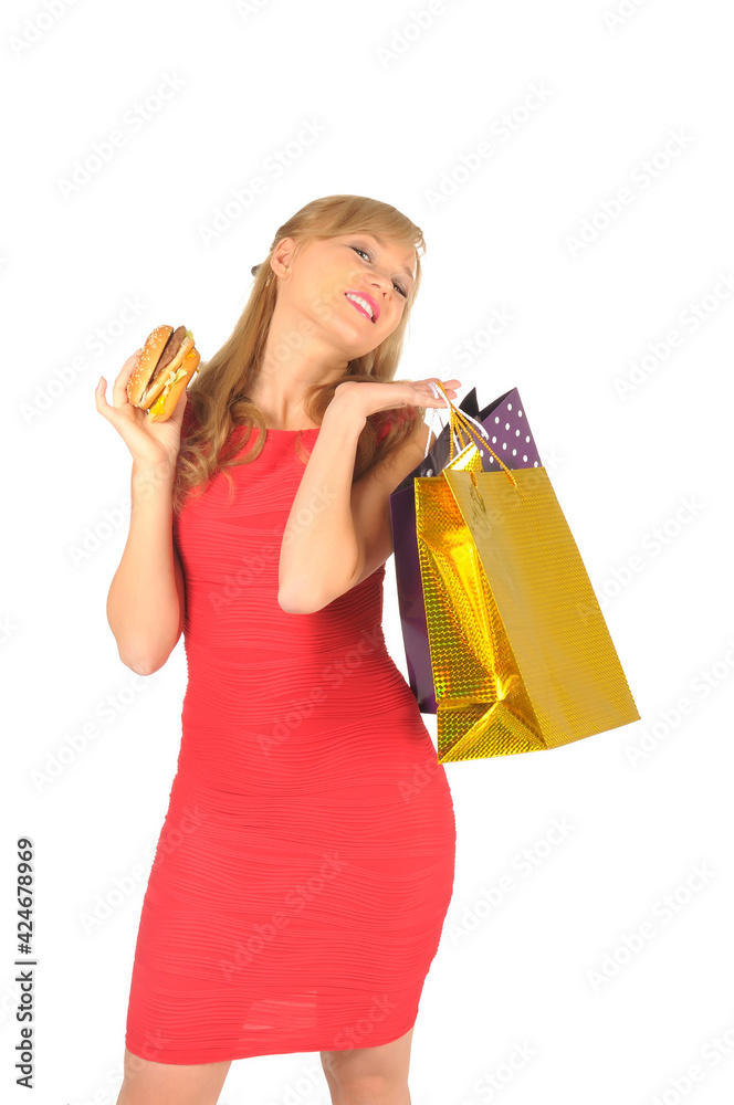 Young beautiful woman with some shopping bags and hamburger isolated on white Young beautiful woman with some shopping bags and hamburger isolated on white
