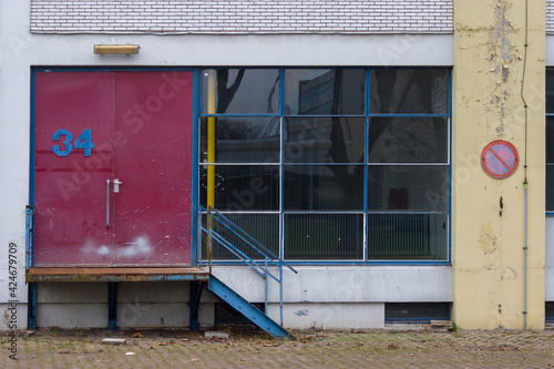 Facade from sixties with large window and loading bay in the netherlands. Dutch architecture from the 60s.